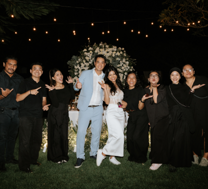 The About Wedding team celebrating with newlyweds at an evening reception