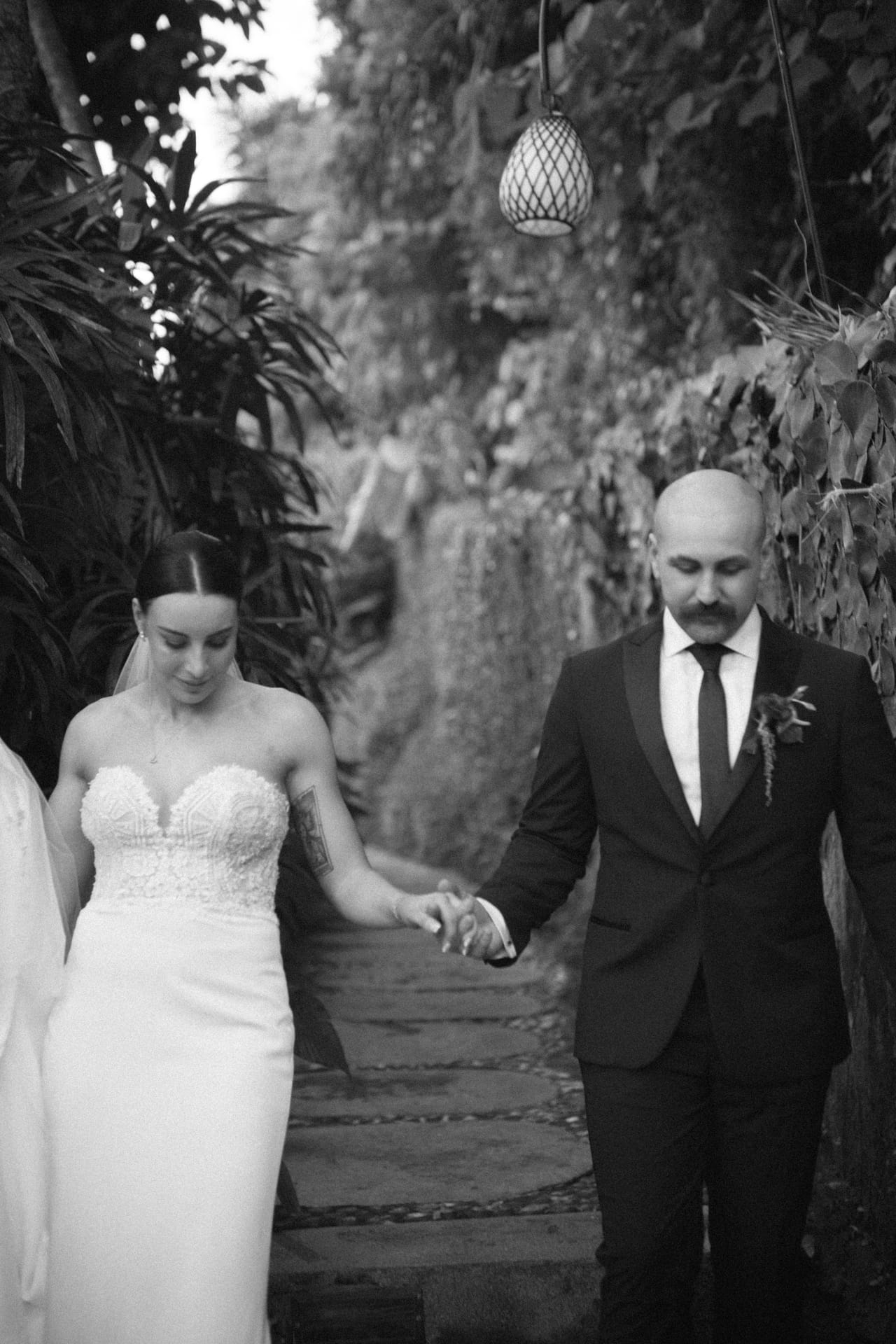 A newly married couple walking hand in hand through a tropical Bali garden