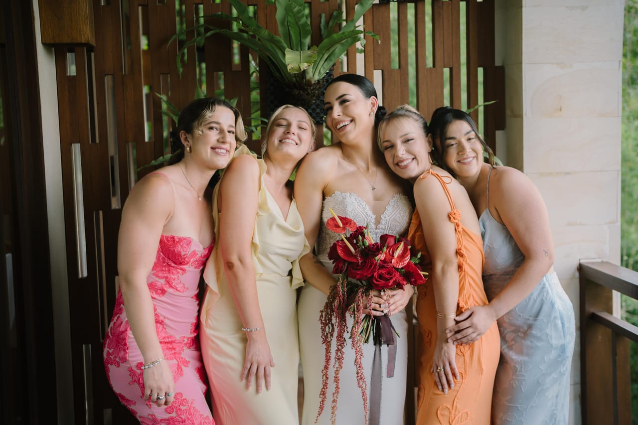 A bride smiling with four friends before her Bali wedding